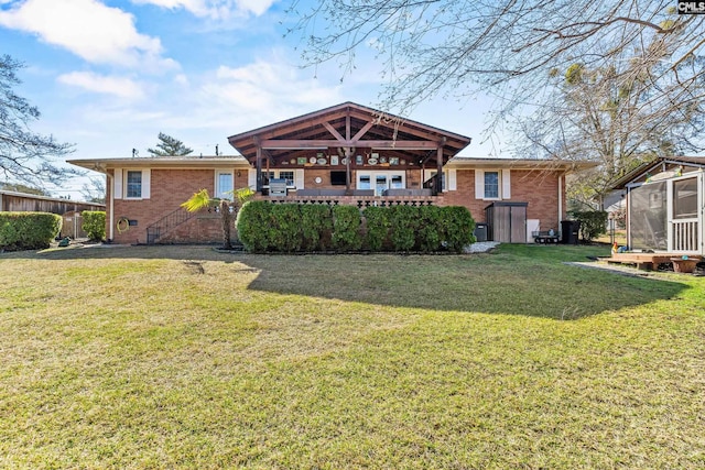 rear view of house featuring crawl space, a yard, and brick siding