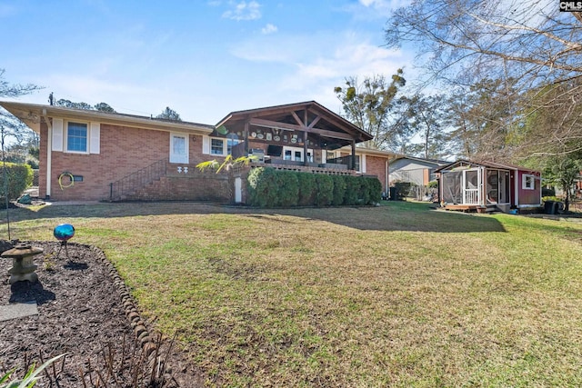 rear view of house featuring an outdoor structure, a lawn, and brick siding