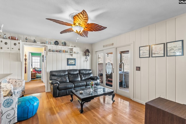 living area featuring french doors, a ceiling fan, and light wood finished floors