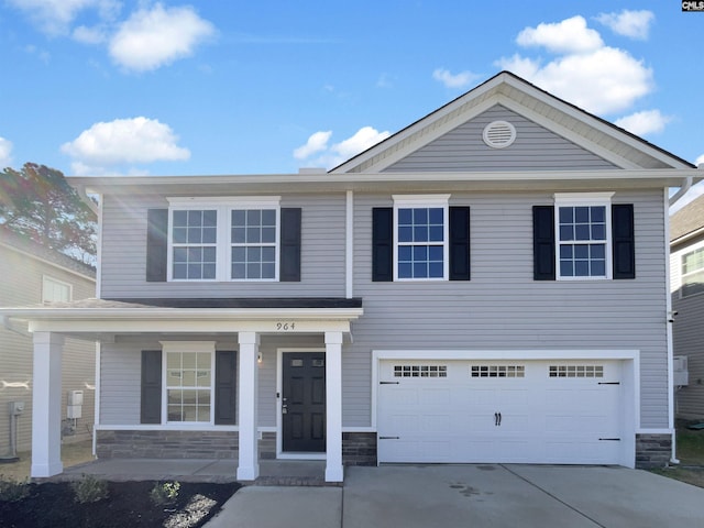 view of front of house with a porch, stone siding, an attached garage, and driveway