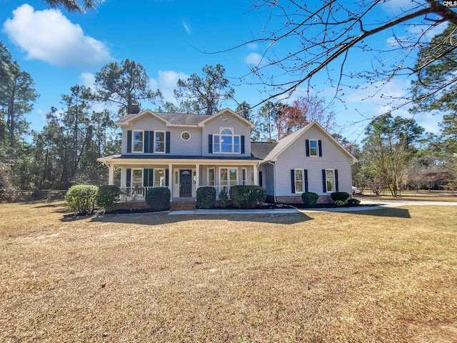 view of front of house featuring a front lawn, a porch, and a chimney