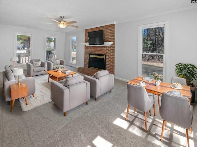 living room featuring a brick fireplace, carpet flooring, and a ceiling fan