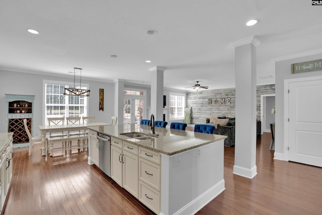 kitchen featuring dishwasher, crown molding, dark wood finished floors, and a sink