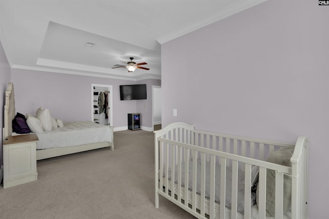 carpeted bedroom with visible vents, baseboards, ornamental molding, and a ceiling fan