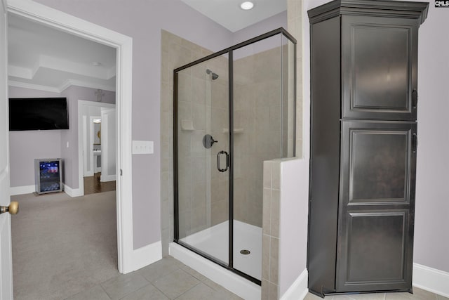 full bath featuring beverage cooler, baseboards, ornamental molding, a shower stall, and tile patterned floors