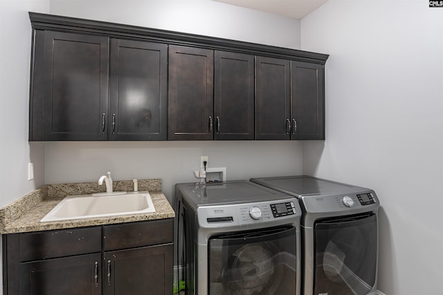 laundry area featuring a sink, cabinet space, and washing machine and clothes dryer