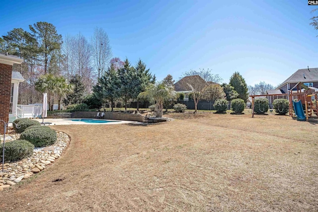 view of yard with a fenced in pool, playground community, and fence