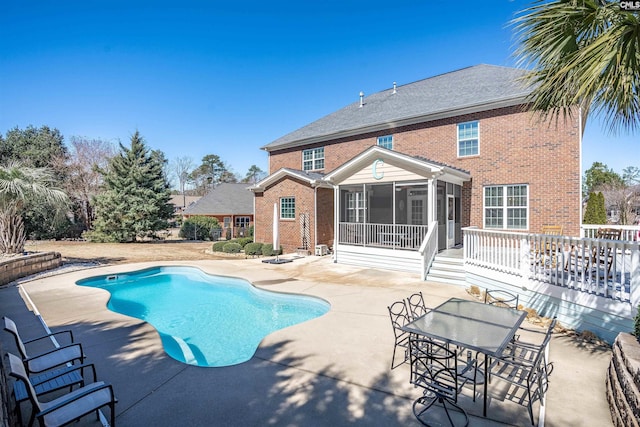 outdoor pool with a patio area and a sunroom