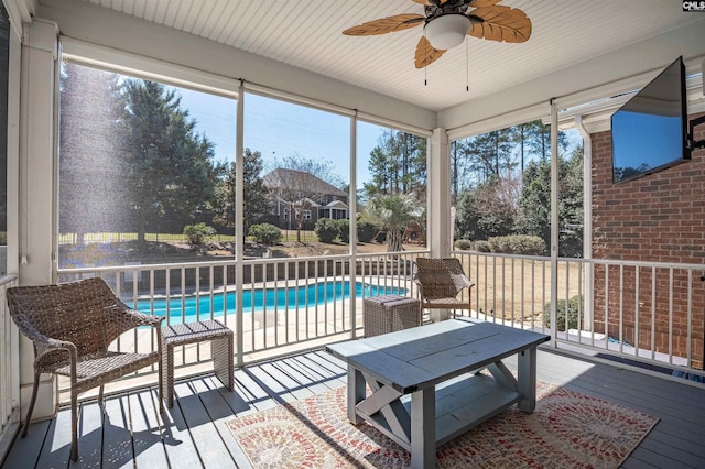 sunroom / solarium featuring a ceiling fan