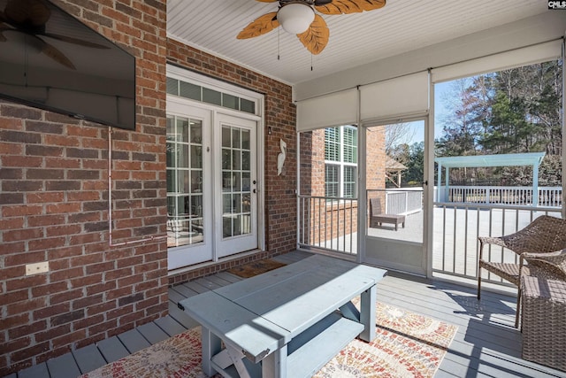 sunroom / solarium featuring a ceiling fan