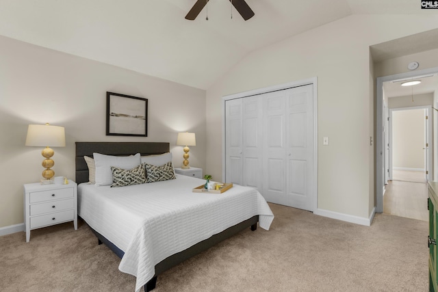 bedroom featuring a closet, lofted ceiling, baseboards, and carpet flooring