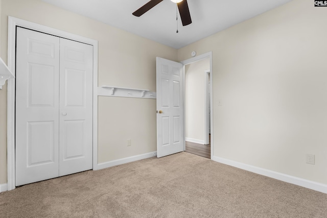 unfurnished bedroom with a ceiling fan, carpet, baseboards, and a closet