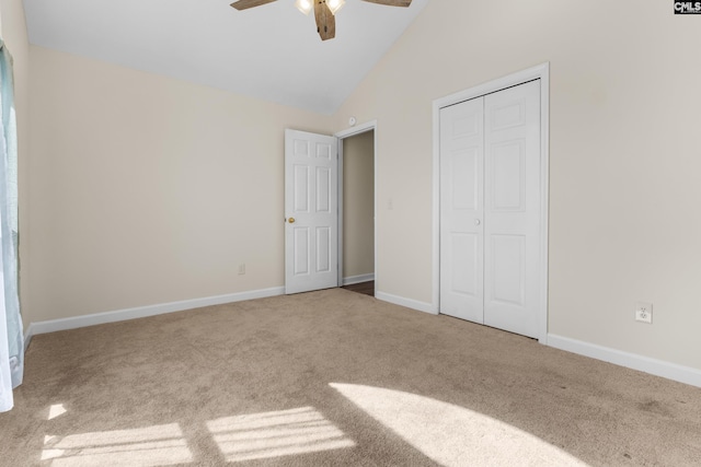 unfurnished bedroom featuring ceiling fan, baseboards, carpet floors, a closet, and high vaulted ceiling