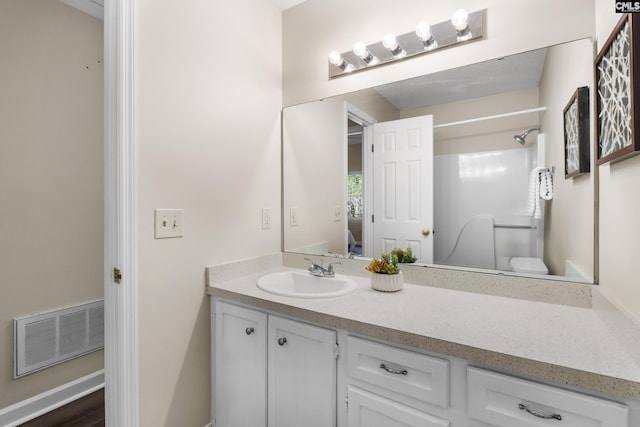 bathroom featuring vanity, visible vents, and walk in shower