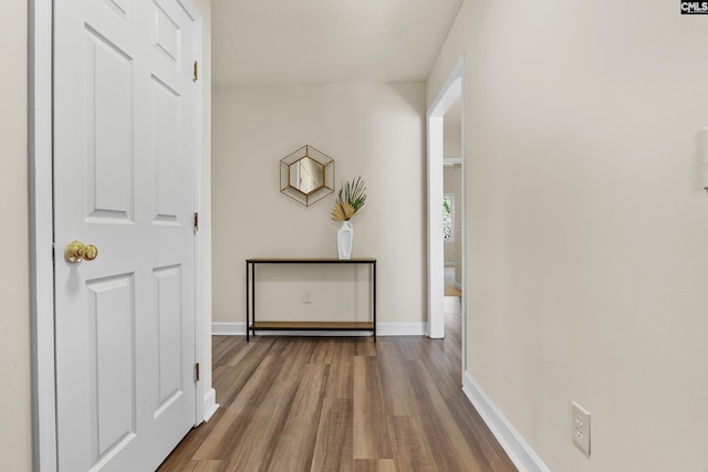 hallway featuring baseboards and wood finished floors