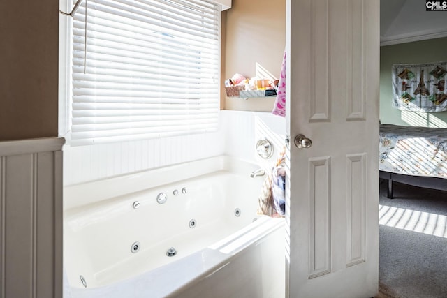 ensuite bathroom featuring ensuite bath, crown molding, and a tub with jets