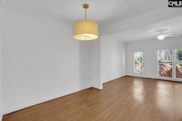 unfurnished room featuring ceiling fan, wood finished floors, baseboards, and ornamental molding