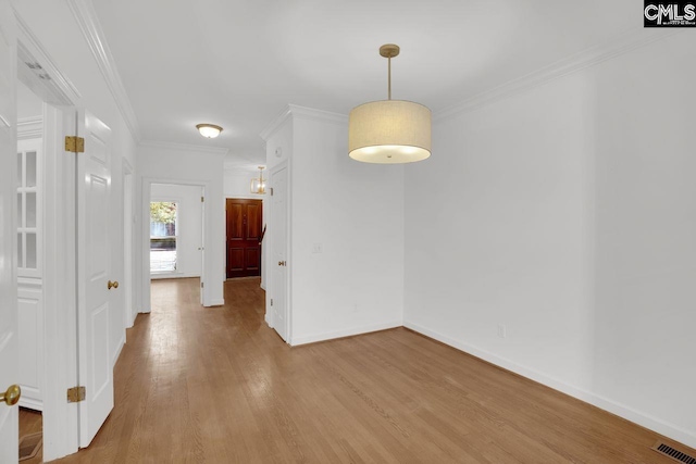 unfurnished dining area featuring visible vents, light wood-type flooring, baseboards, and ornamental molding