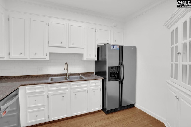 kitchen featuring a sink, stainless steel appliances, dark countertops, and white cabinets