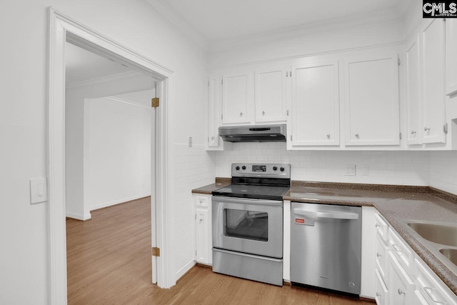 kitchen featuring under cabinet range hood, white cabinetry, stainless steel appliances, and crown molding