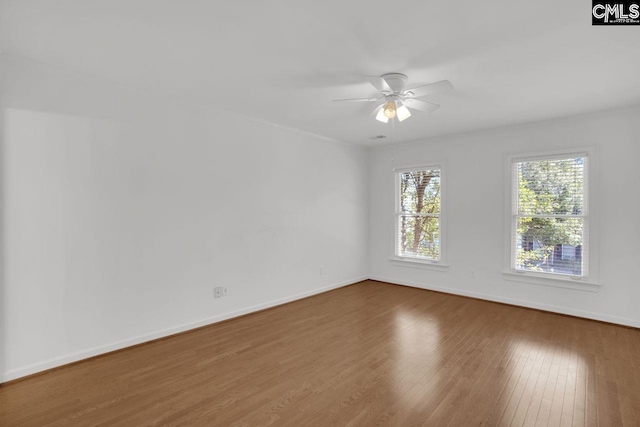 unfurnished room featuring a ceiling fan, baseboards, and wood finished floors