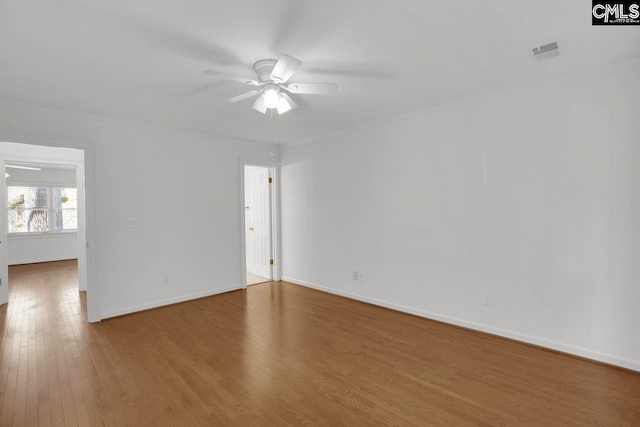 spare room featuring visible vents, baseboards, ceiling fan, and hardwood / wood-style floors