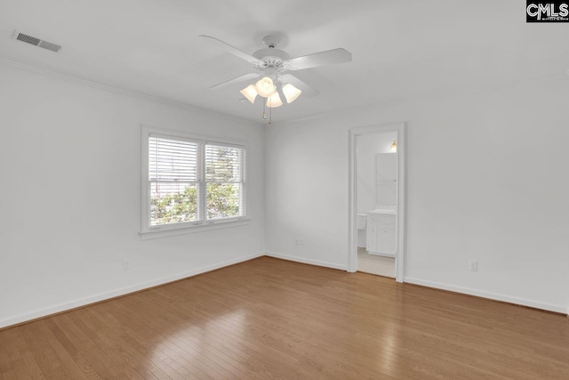 spare room featuring visible vents, baseboards, a ceiling fan, and hardwood / wood-style flooring