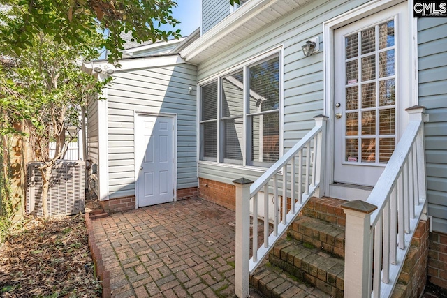 entrance to property with cooling unit and a patio