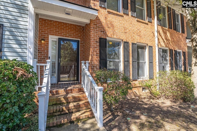 doorway to property with brick siding