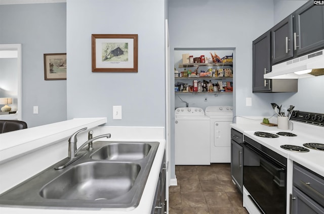 kitchen with a sink, light countertops, under cabinet range hood, range with electric stovetop, and washer and clothes dryer