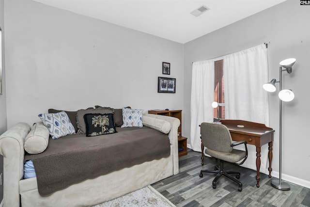 bedroom featuring visible vents, baseboards, and wood finished floors