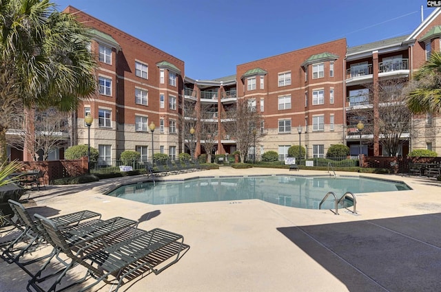 community pool featuring a patio area and fence