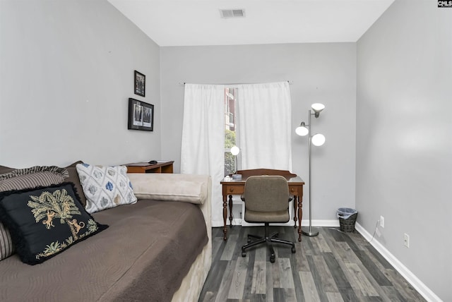 bedroom with visible vents, baseboards, and wood finished floors