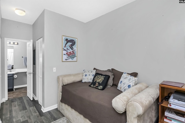 bedroom with a closet, baseboards, and dark wood finished floors