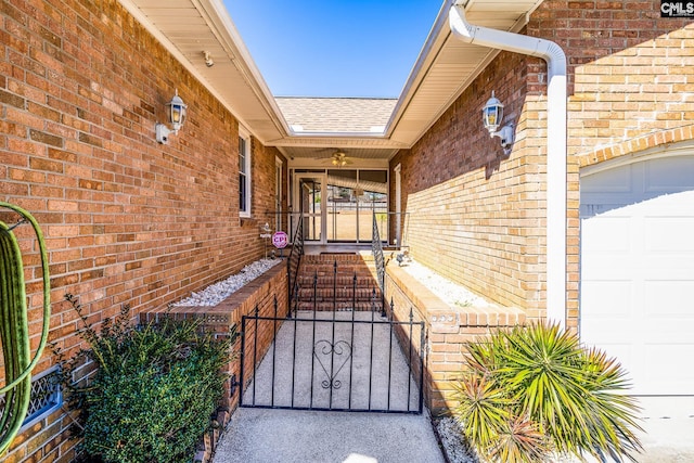 doorway to property featuring brick siding, roof with shingles, an attached garage, and a gate