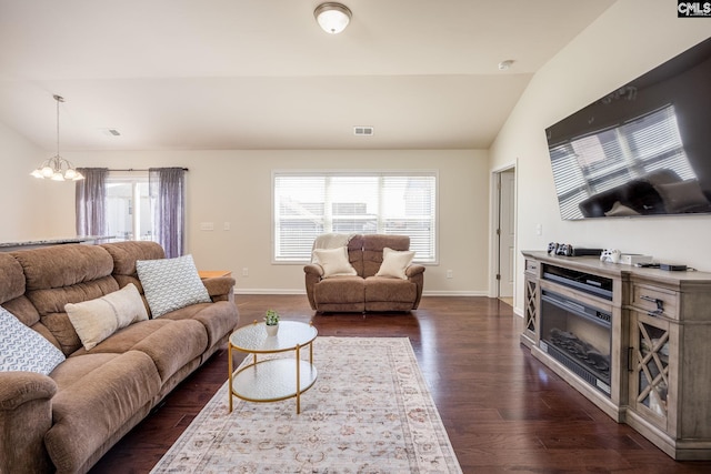 living room featuring dark wood finished floors, lofted ceiling, visible vents, and a wealth of natural light