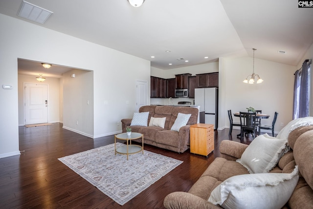 living room with visible vents, a notable chandelier, dark wood-style floors, baseboards, and lofted ceiling