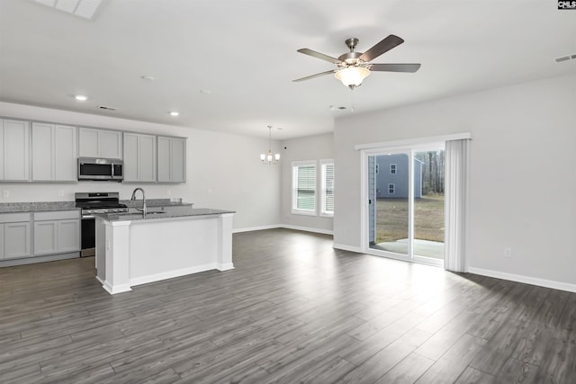 kitchen with visible vents, ceiling fan with notable chandelier, open floor plan, dark wood finished floors, and stainless steel appliances