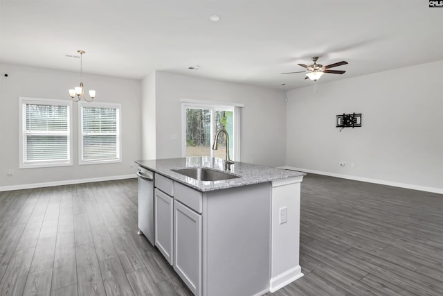 kitchen with dishwasher, dark wood finished floors, open floor plan, and a sink