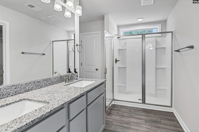 full bath featuring a shower stall, wood finished floors, visible vents, and a sink