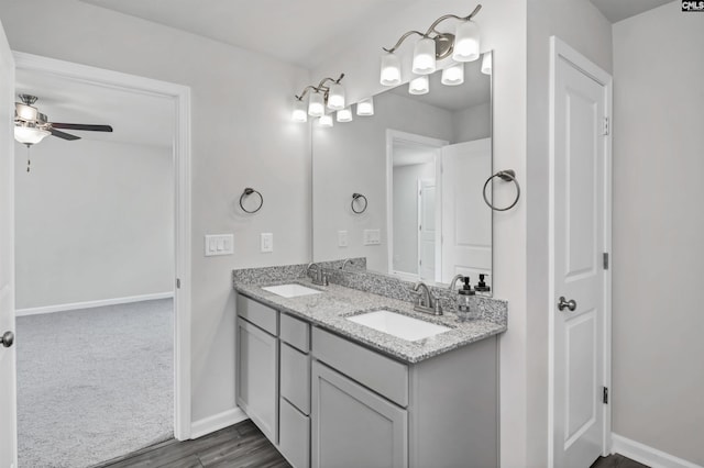 bathroom with ceiling fan, double vanity, baseboards, and a sink