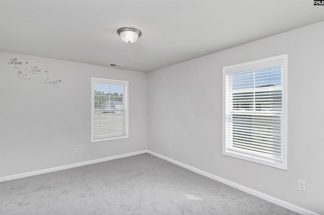 carpeted spare room with baseboards and visible vents