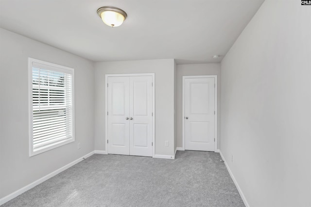 unfurnished bedroom featuring a closet, carpet flooring, and baseboards