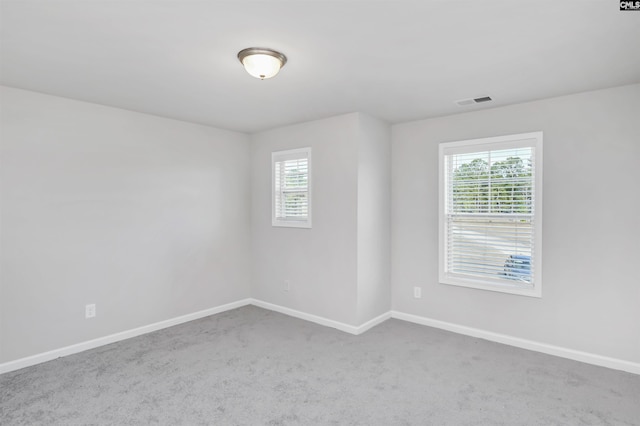 carpeted empty room featuring visible vents and baseboards