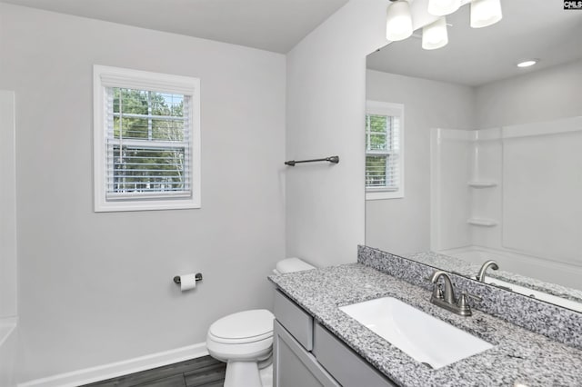 bathroom featuring baseboards, toilet, wood finished floors, and vanity