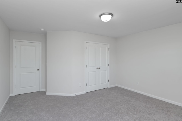 unfurnished bedroom with a closet, baseboards, and carpet