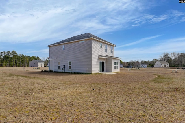 rear view of property featuring a lawn