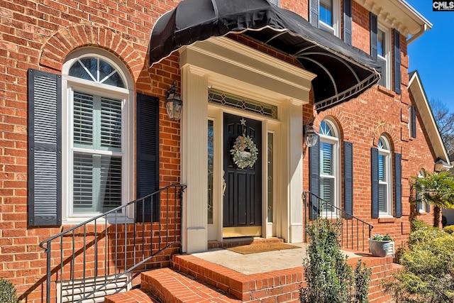 entrance to property featuring brick siding