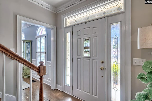 entrance foyer with stairway, plenty of natural light, wood finished floors, and ornamental molding