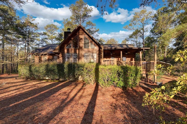 rear view of property featuring a wooden deck and a chimney